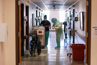 A nurse dons full PPE before entering the room of a COVID-19 patient at Goodall-Witcher Hospital in Clifton on August 3, 2021.