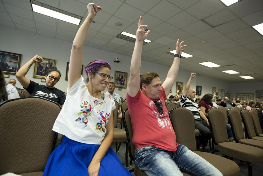 Devyn Gonzales and Gilberto Sanchez raise their arms in support of changing the name of a new course on Mexican-American history to "Mexican-American Studies" at a State Board of Education hearing on Tuesday.