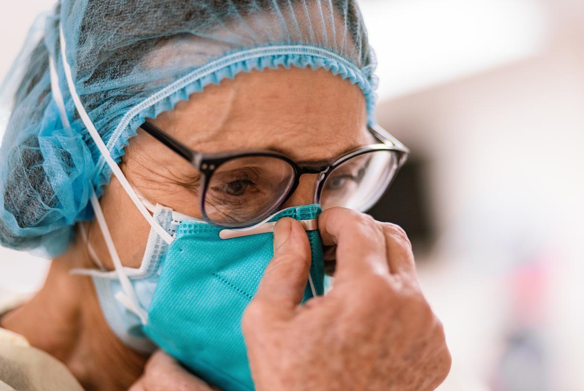 Registered Nurse Lori Kelley dons an N95 mask and other PPE before entering the room of a COVID-19 patient at Goodall-Witcher Hospital in Clifton on Wednesday, August 3, 2021.