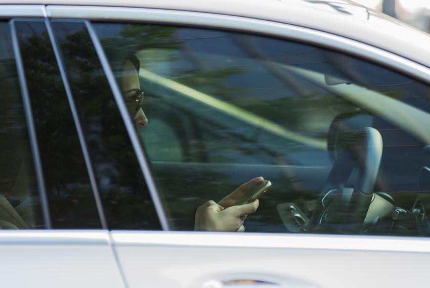 A woman checks her phone while driving in Austin. A statewide texting-while-driving ban goes into effect Sept. 1, 2017.