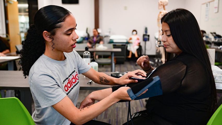 21-year-old Violet Fields measures Nora Hernandez-Mondragon’s blood pressure before class at the Leander Campus of Austin Community College on Oct. 4. The students were participating in a healthcare apprenticeship program for Baylor Scott & White employees.