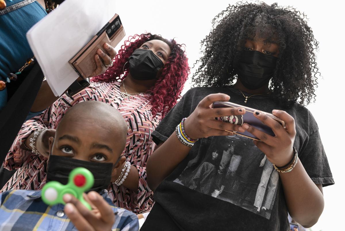 Israel Cheathem, 5, bottom left, waits in line with his sisters Zoey Cheathem, 14, right, and Trinity Cheathem, 15, so the teenagers could receive a COVID-19 vaccine at a site hosted by McKinney ISD and the McKinney Fire Department, on May 20, 2021 outside the McKinney ISD Stadium and Community Event Center in McKinney, Texas. McKinney ISD students ages 12 or older, along with their parents, received the first dose of the Pfizer vaccine. Ben Torres for the Texas Tribune