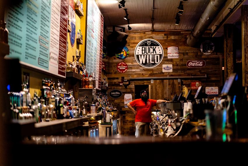 A bartender waits for customers at Buck Wild on West Sixth Street in downtown Austin as bars reopen on May 22, 2020.