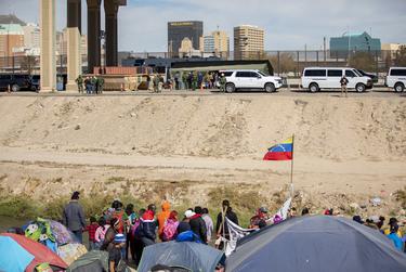 Migrants standing near the Rio Grande in Juárez, Mexico look on as Congressman Kevin McCarthy and GOP Leader in the U.S. House of Representatives and other members of the GOP tour the makeshift migrant processing center near the Rio Grande on Tuesday, Nov. 22, 2022, in El Paso.