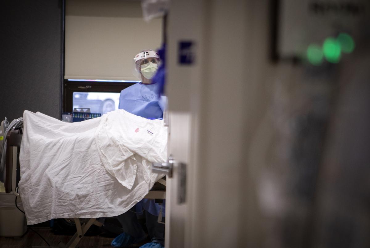 A nurse checks on a patient in the COVID-19 unit at Doctors Hospital at Renaissance Health System in Edinburg.