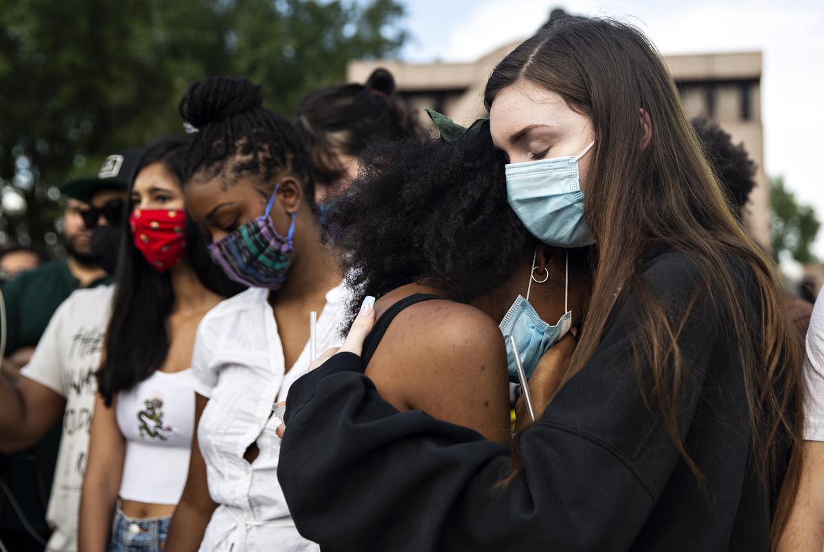 From right, Taylor Putnam comforts her friend Veronica Holmes at a vigil honoring those who's lives were lost to police shootings at Freedman's Memorial Cemetery on May 31, 2020. 