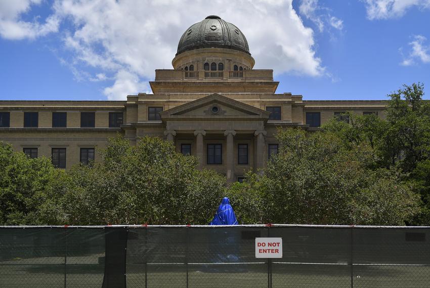 The statue of former Texas A&M President Lawrence Sullivan "Sul" Ross, a former Confederate general and Texas governor, is fenced in and covered by a blue tarp at Texas A&M University in College Station on June 15, 2020.