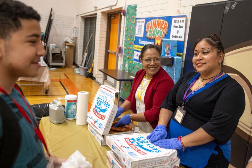 AUSTIN, TEXAS - July 24, 2025: Carmen Mendoza, center, volunteers with Austin Voices to serve lunch to campers and staff at the camp. Austin Voices for Education and Youth hosts a summer camp at the Dobie Middle School for students that attend the three Austin ISD schools at risk of closure. Ilana Panich-Linsman for The Texas Tribune