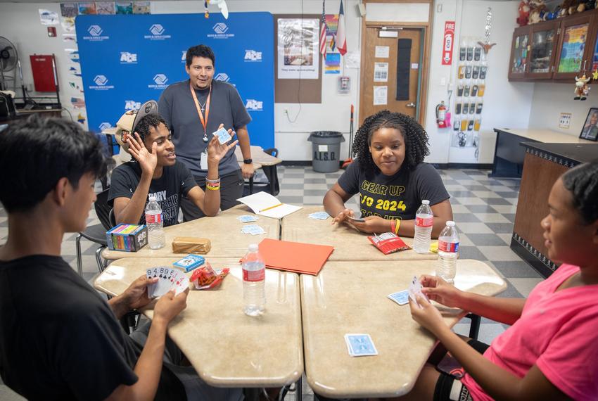 Club director Jacob Hernandez (center) watches club members Daniel, Ray, Kaitlyn and Candice (left to right) play spades at Navarro Early College High School in Austin, Texas on July 22, 2025. Photo by Montinique Monroe for the Texas Tribune
