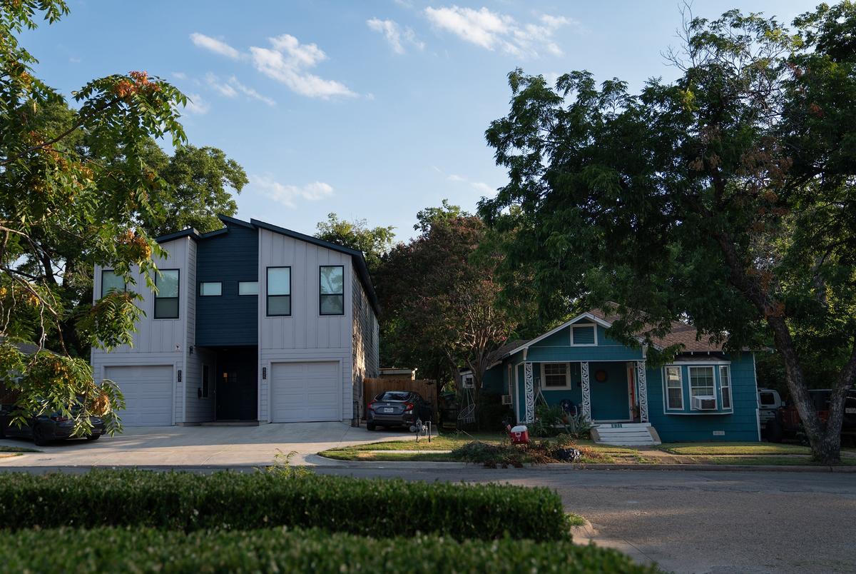 Newly developed apartments sit next to older homes in Dallas' Oak Cliff neighborhood on July 11, 2024.