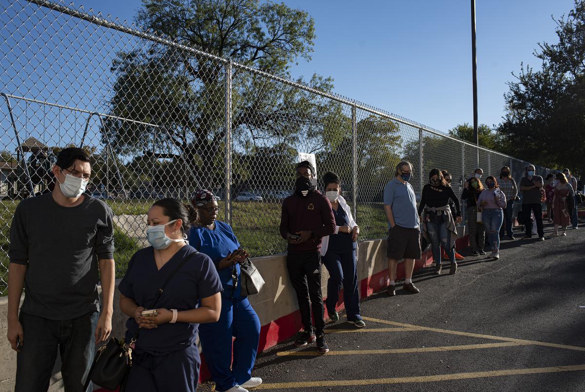 Voters wait in line outside Cody Public Library in San Antonio during the evening hours of Election Day. 