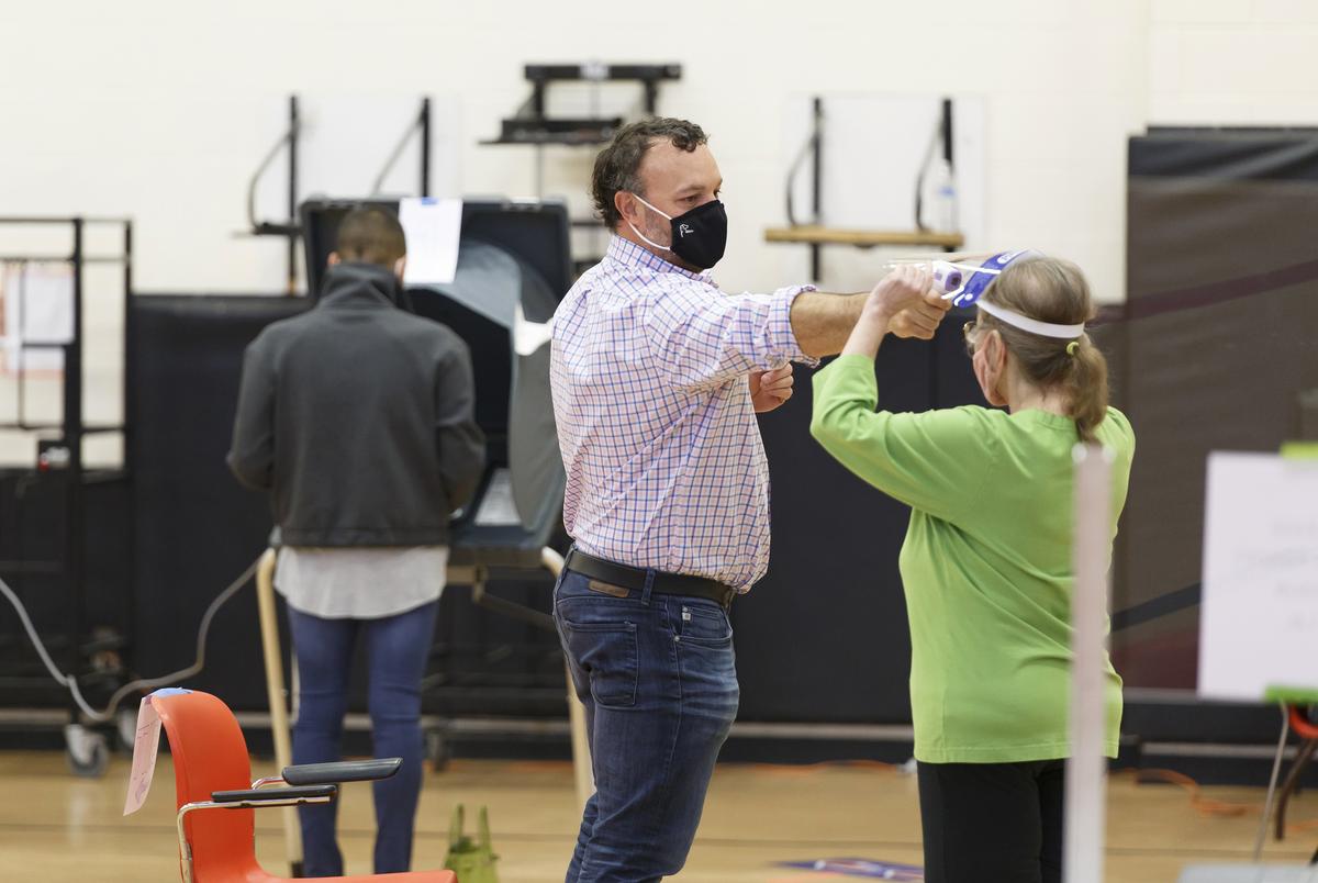 Poll workers get their temperature checked at the Metropolitan Multi-Services Center in Houston on Nov. 3, 2020.