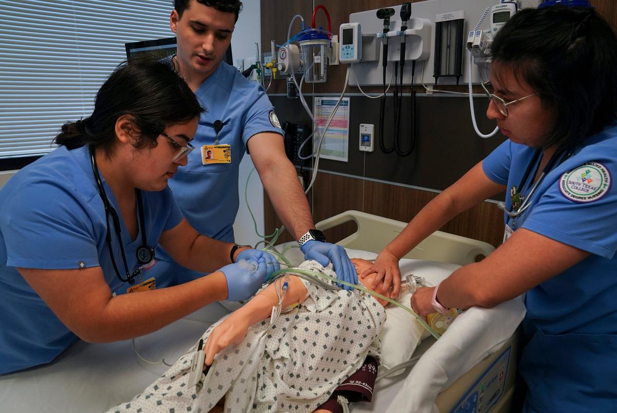 Students from left, Victoria Zamora, Michael Hunter Maldonado, and Emily Luna, practice their knowledge and skills on a manikin during class at a simulating hospital at South Texas College in McAllen, Texas on Dec. 6, 2024.
Gabriel V. Cárdenas for The Texas Tribune