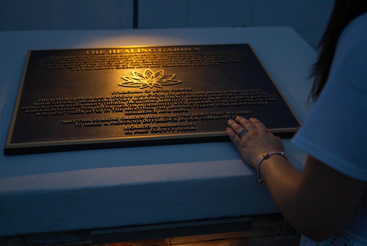 Jamie reads a dedication plaque at the Healing Garden on Wednesday evening. In 2019, Jamie was pregnant and an employee at a bank inside of Walmart when the shooting occurred.