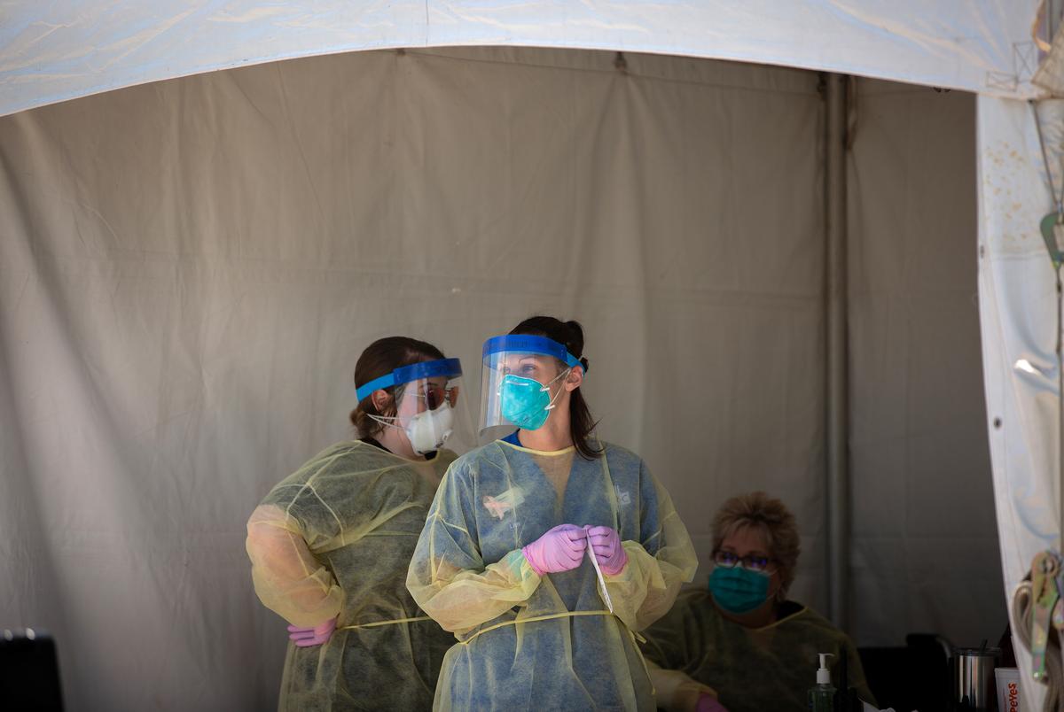 Nurses Amber Phillips, left, and Kristen Howell administer COVID-19 tests at the Austin Regional Clinic drive-up testing center in Kyle on March 31, 2020.