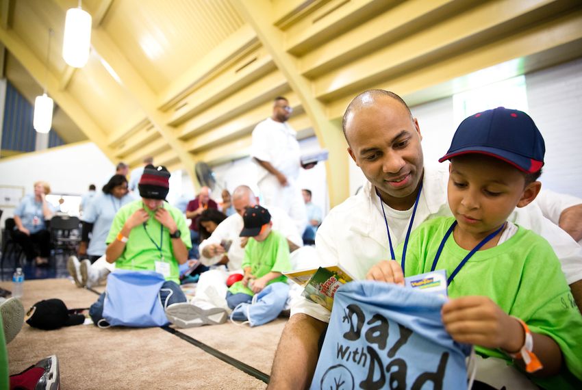 A boy opens a gift bag from his father, an inmate at a maximum-security facility south of Houston during a 2016 gathering for prisoners and their children called Day with Dad. A new study looked at the impact incarceration has on prisoners' families.