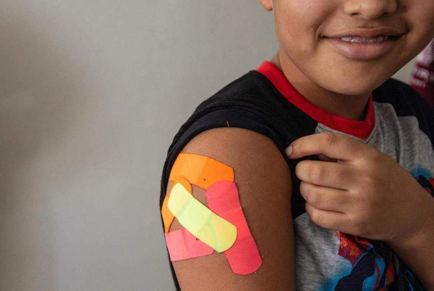 Omar Wahidi, 12, shows the bandaids from vaccines given to him in his right arm on August 13, 2025. In order for him to attend school, he needed to receive all the required medical vaccinations.