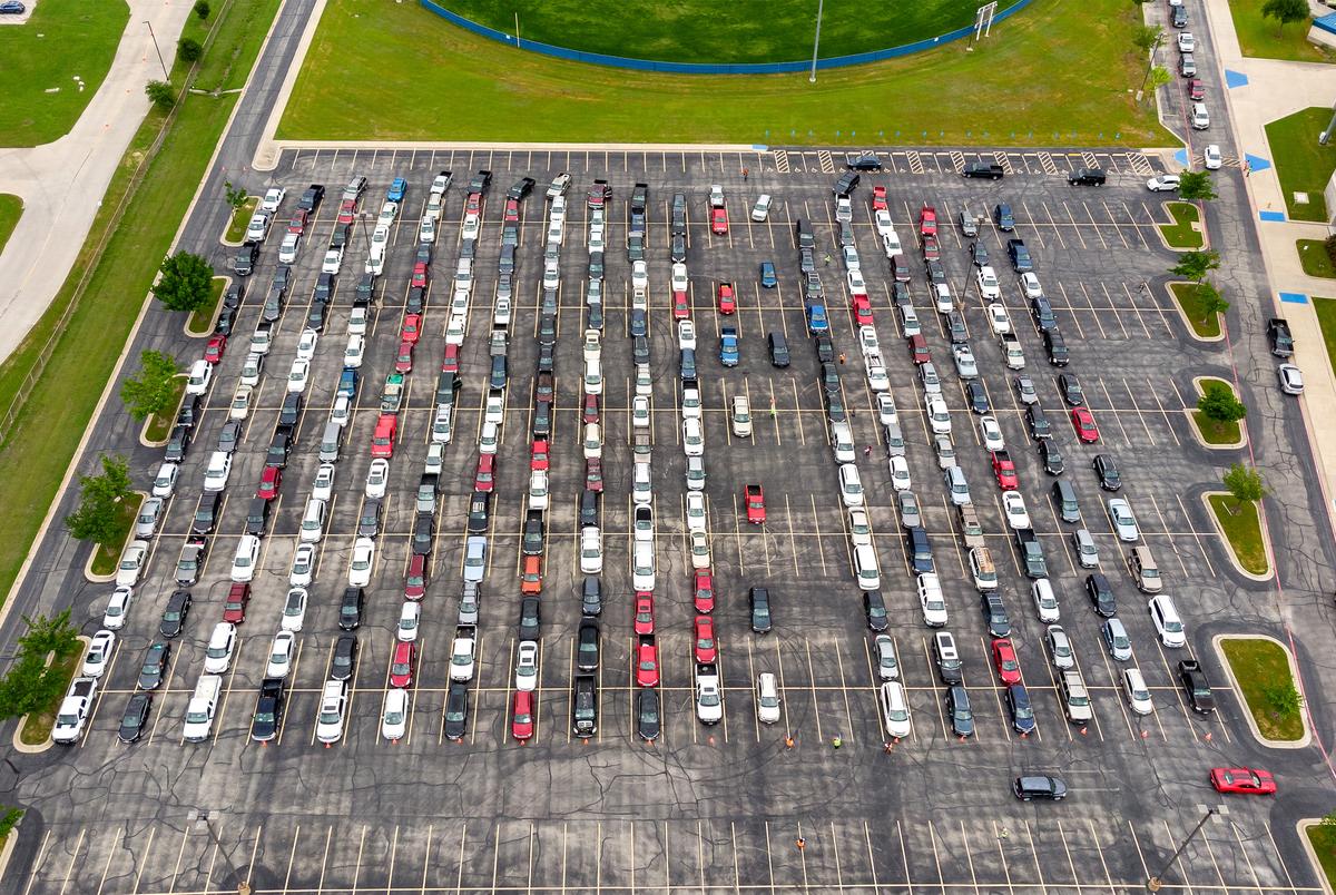 The parking lot of the Waco ISD Stadium is full of cars waiting to receive disaster relief food boxes from the Central Texas Food Bank on April 14, 2020.