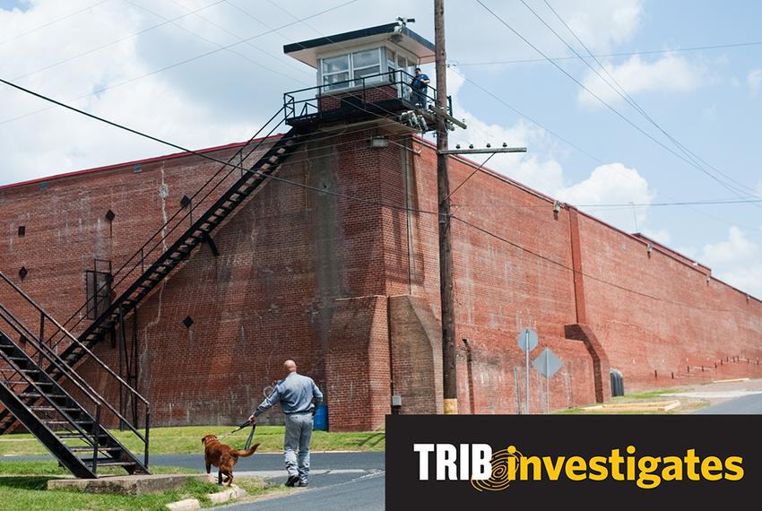 Correctional officer Mike Warren walks with his contraband detector dog, Gus, during a demonstration of how the dog seeks out cellphones around the Texas State Penitentiary in Huntsville on Wednesday, April 23, 2014.