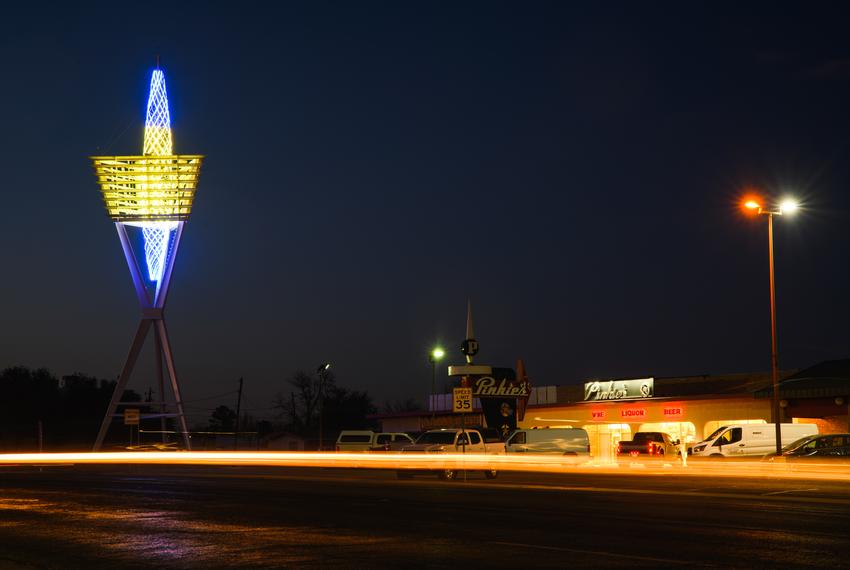 Motorists drive past the Odessa Spire as its core is lit in the colors of the Ukrainian flag in support of Odessa’s sister city in the Ukraine as the country faces war with Russia on March 16, 2022.