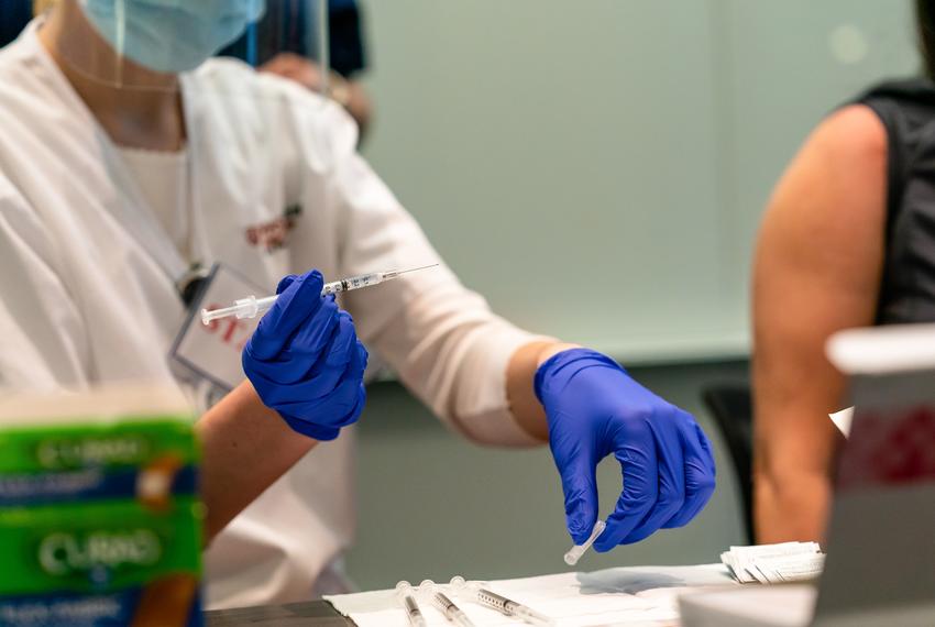 Holly Ainsworth, a nursing intern at the University of Texas, prepares to administer a COVID-19 vaccine to Stephanie Vasquez in Austin on Dec. 15, 2020.