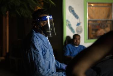Juan Lopez speaks to the family members of a recently deceased relative. The person tested positive for COVID-19, and Lopez reminded them of the importance of wearing masks to prevent the spread of the disease. Lopez said he had been working long hours and wasn't sure how much more he could endure.