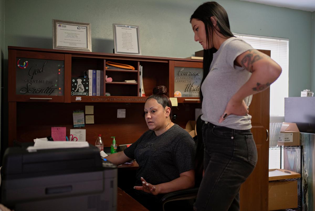Mindy Anderson, left, and Charlotte Loving, right, who are house managers of House of Extra Measures homes, work in the office on February 27, 2025, in Houston, Texas. Loving was also a previous resident of a House of Extra Measures home.