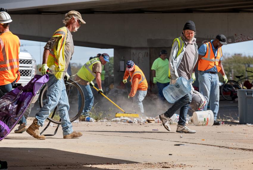 TXDOT workers remove trash and personal belongings from a homeless encampment under Highway 290 at Westgate Blvd in Austin on Nov. 4, 2019. 