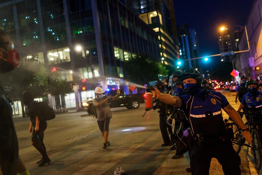 A police officer sprays a protester with pepper spray as protestors clashed with police in riot gear in downtown Austin on Aug. 1, 2020.