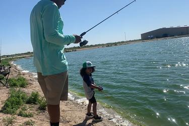 Joseph Norman fishes with his son at a saltwater pond in Imperial.