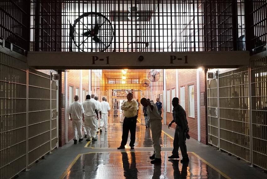 Prison staff and inmates move through the Darrington Unit's main hallway on Wednesday, July 12, 2017.