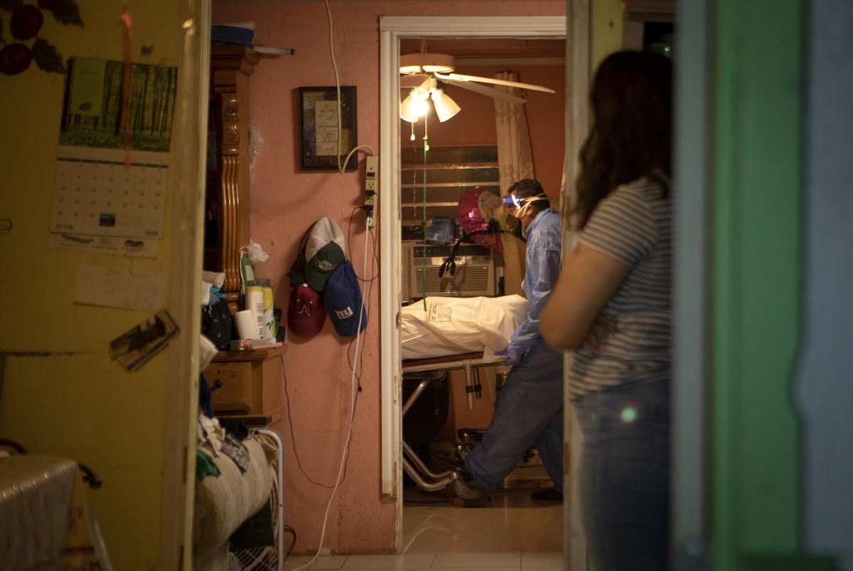 Juan Lopez works to remove a dead body from a home in McAllen. The person recently died from COVID-19. July 17, 2020. 