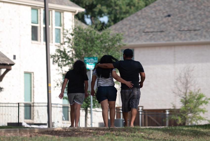A family walks through a neighborhood in Irving on Aug. 1, 2024.
