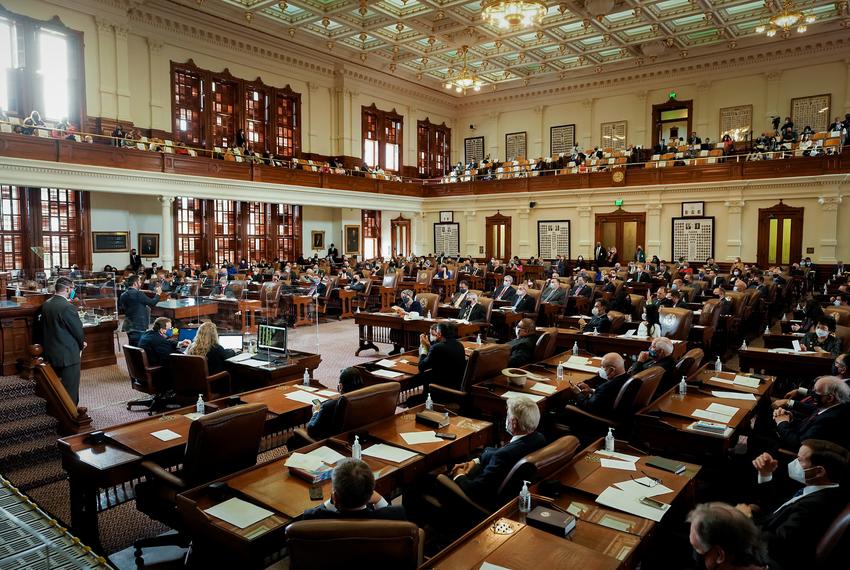 Legislators greet each other on the floor of the House of Representatives prior to the opening of the 2021 Legislative Session.