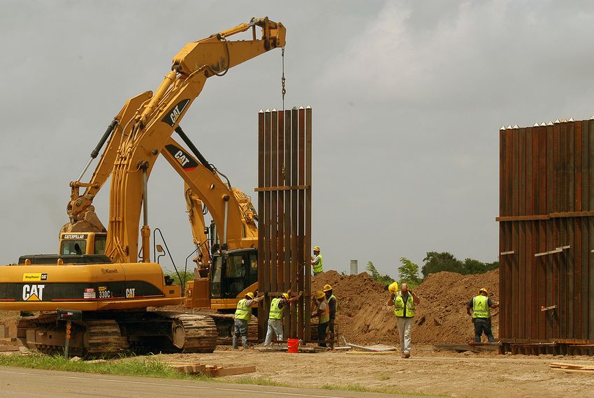 A construction crew works to erect a portion of the border wall along Oklahoma Ave. south of Brownsville on June 9, 2009.              