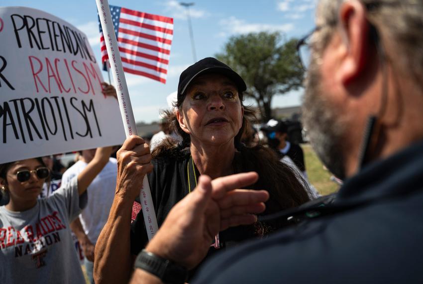 An Odessa Police Department officer, right, confronts a counter protestor as she walks through a crowd of No Kings Day demonstrators after jaywalking through a busy intersection on Saturday, June 14, 2025, in Odessa.