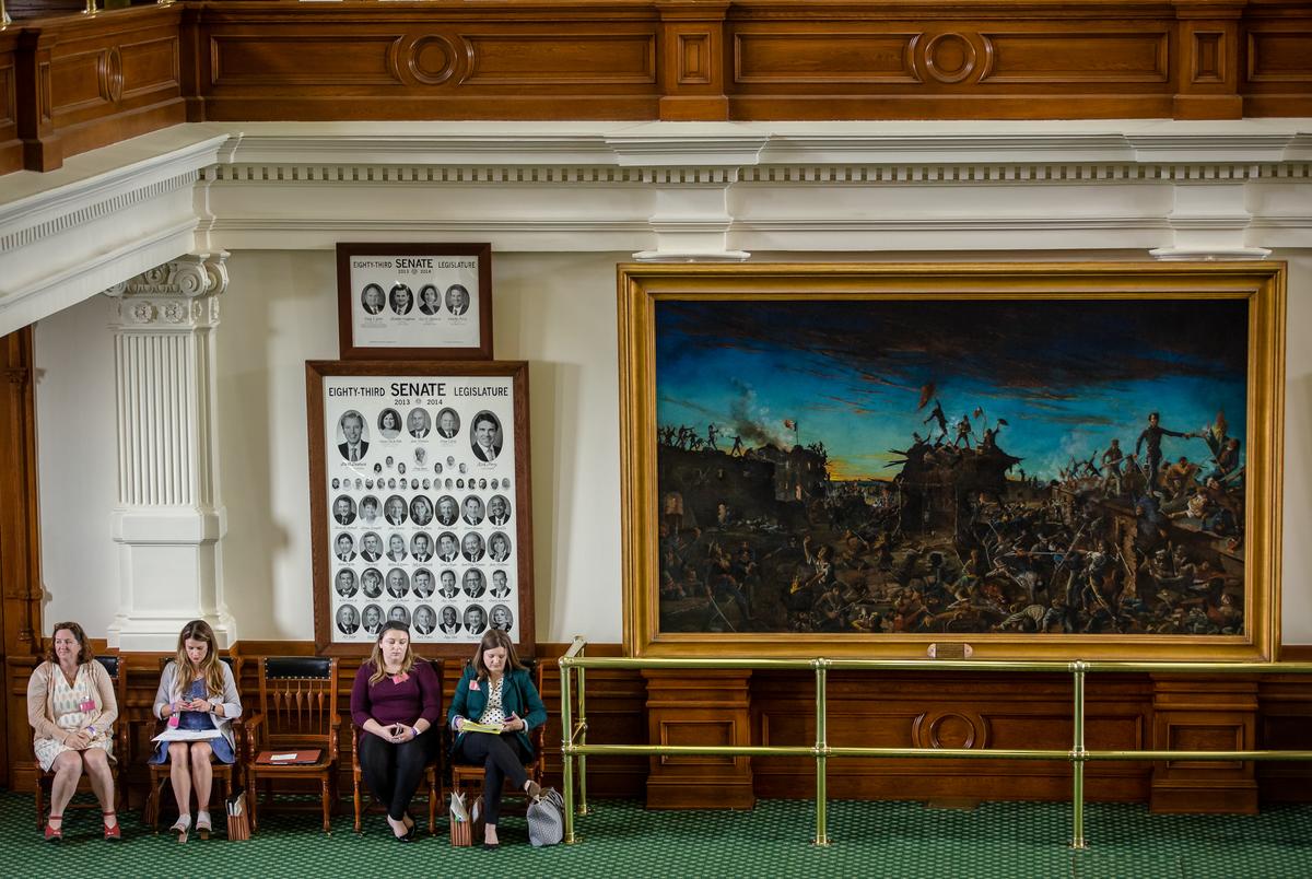 People wait on the Senate floor during session at the state capitol on May 25, 2021.
