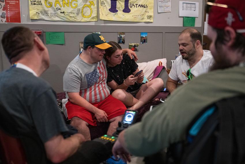 Camp counselor Grace Benesch, center right, reads a story to campers during Toes Up Time, a rest hour after lunch, at Camp CAMP, a summer camp hosted by Children’s Association for Maximum Potential for people with disabilities, on Tuesday, July 22, 2025, in Center Point.