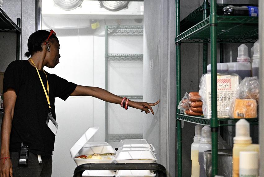 Nettie Carlisle, a cook at Ella Springs Senior Living Community in Houston, holds open the empty freezer at the assisted living center on July 12, 2024. All the food had to be thrown out after the widespread power outage caused by Hurricane Beryl.