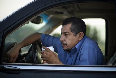 Juan Lopez drinks coffee during a break from his busy morning of picking up bodies and delivering them to funeral homes. From approximately 4:30 to 7:30 in the morning, Lopez delivered four cadavers to local funeral homes. They were all coronavirus-related deaths.