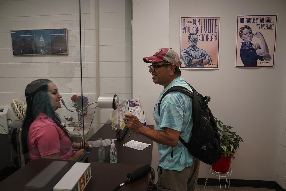 Jessika Morales, 33, assists Francisco Jubera, 63, who just moved into the county, to register to vote at the Nueces County Courthouse in Corpus Christi, Texas on Sept. 11, 2024.