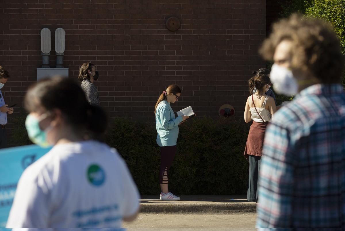 Voters stand in line at the Oak Lawn Branch Library to cast their ballots on Election Day in Dallas. Nov. 3, 2020.