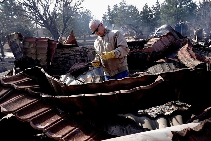 Hugh Lively sifts through the remains of his sister's home that was destroyed by the Smokehouse Creek wildfire, in Canadian, on Feb. 28, 2024.
