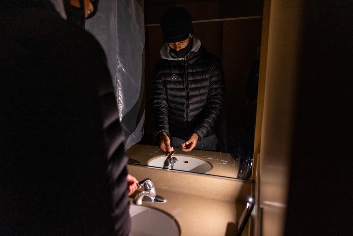 Nicholas Ware, a freshman computer science major at Texas State University, washes his hands in a dark bathroom using the flashlight on his phone on Feb. 17, 2021.