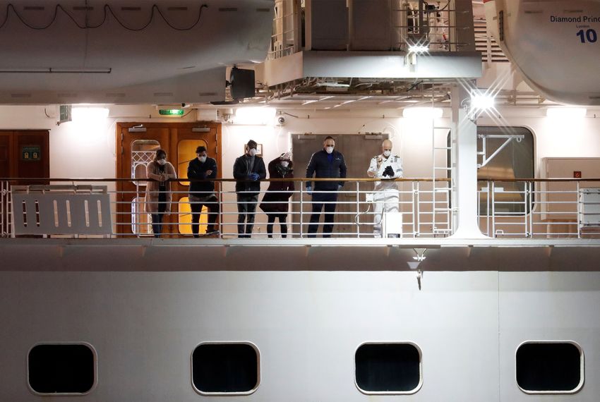 Passengers on the Diamond Princess cruise ship wave to those who have disembarked at the Daikoku Pier Cruise Terminal in Yokohama, Japan.