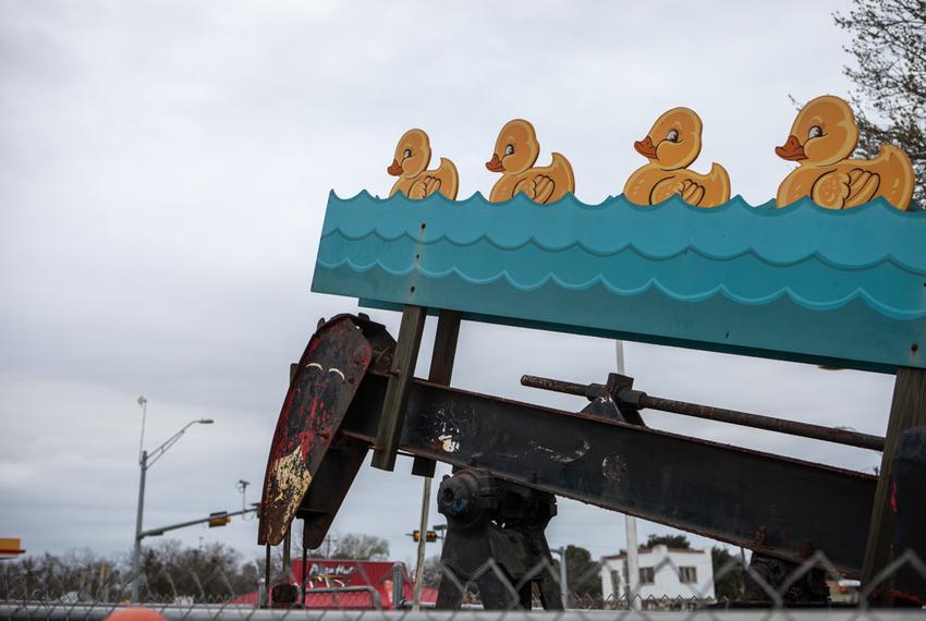 In a grocery store parking lot, these swimming ducks bob up and down with the pump jack. 