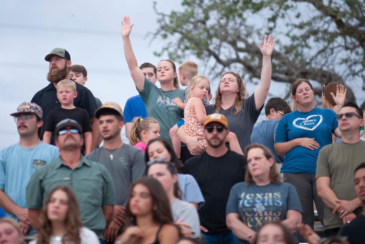 People pray during a Kerr County Blessing at Antler Stadium on Wendsday July 9, 2025 in Kerrville, Texas.
