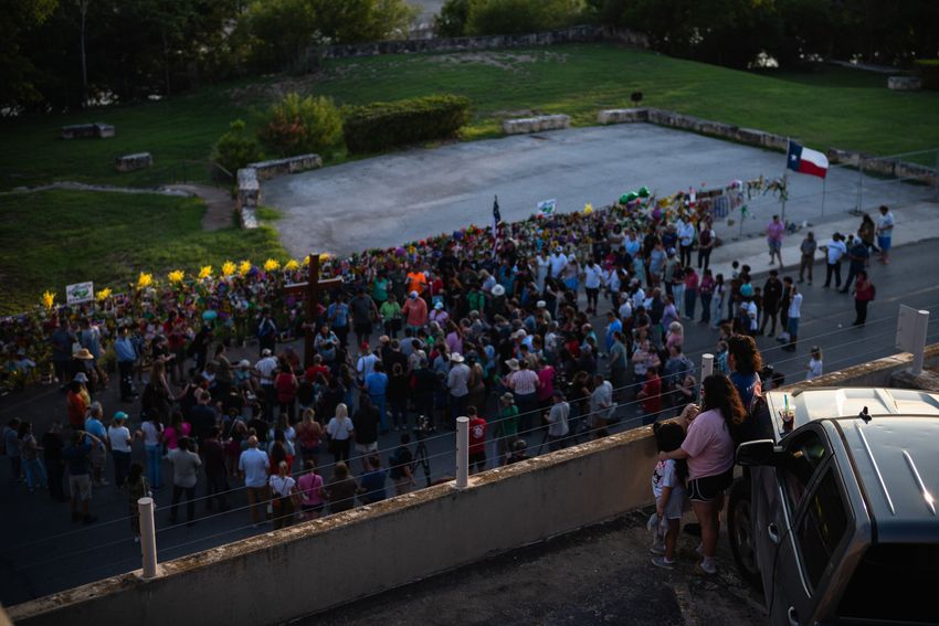 A family watches a vigil in memorial of the victims of the Kerr County flood from atop a parking garage on Friday, July 11, 2025, in Kerrville.