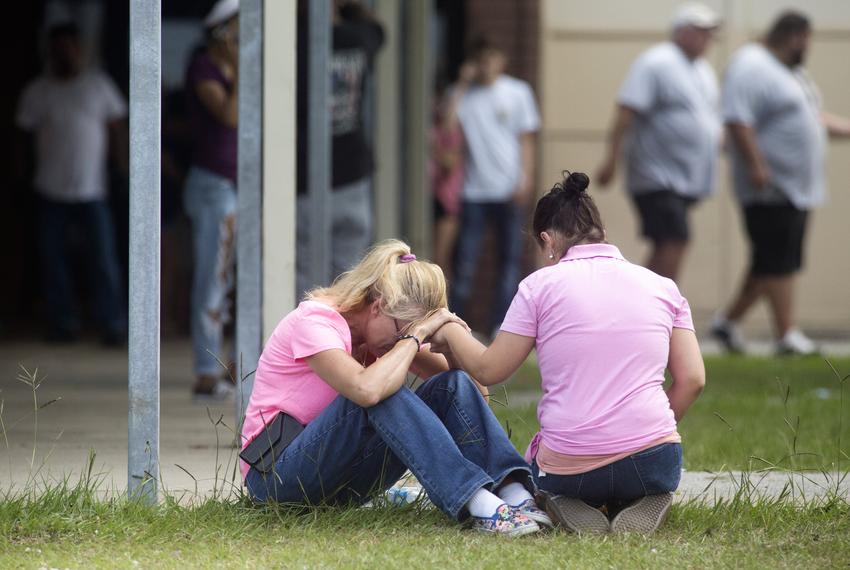 People outside a middle school set up as a reunion point for parents and students in Santa Fe, Texas on Friday, March 18, 2018 after a gunman killed 10 people at Santa Fe High School.