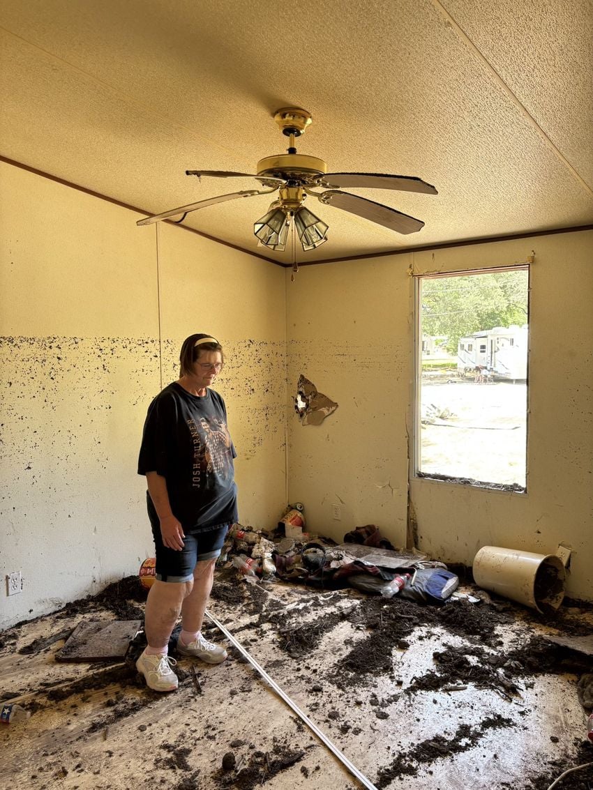 Tammy Roe stands in her former bedroom in the home of her step-father Harry Sherwood. “The mud was so thick in here and I shoveled it all outside trying to find my mom’s knicknacks,” she said. “That’s all I have left of my mom.”